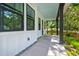Inviting porch with white siding, a blue ceiling, dark pillars, and tranquil view of the surrounding nature at 110 Cypress St, Summerville, SC 29483