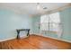 Bedroom with pale-blue walls, wood floors, a decorative ceiling light, and large window with white curtains at 112 Retriever Ln, Goose Creek, SC 29445