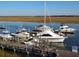 Waterfront marina featuring multiple boats and yachts docked along a wooden pier at 116 Bay Creek Villa, Edisto Beach, SC 29438
