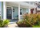 Front porch with columns, exterior light fixture, and ornamental bushes at 122 Yorkshire Dr, Moncks Corner, SC 29461