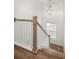 Staircase with wooden handrail and white wainscoting, complemented by a decorative chandelier at 122 Yorkshire Dr, Moncks Corner, SC 29461