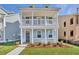 Two-story home with a charming porch, complemented by lush green grass and landscaping at 128 Cantona Dr, Summerville, SC 29483