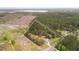 This is an aerial shot showing property lines, a home, barns, and surrounding acreage with mature foliage in the background at 1298 French Santee Rd, Jamestown, SC 29453