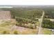 A high aerial of the property showcasing the home, barns, and beautiful surrounding wooded acreage within the property lines at 1298 French Santee Rd, Jamestown, SC 29453