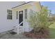 Charming front entrance with a black door, white siding, and a blooming bush at 1298 French Santee Rd, Jamestown, SC 29453