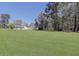 Expansive front yard with a well-manicured lawn, mature trees, and a view of the home and three-door garage at 1298 French Santee Rd, Jamestown, SC 29453
