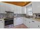 Updated kitchen with white cabinetry, stainless steel appliances, and mosaic backsplash at 1298 French Santee Rd, Jamestown, SC 29453