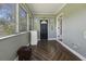 Bright sunroom with tiled floors, multiple windows, and a black door leading to the outdoors at 1298 French Santee Rd, Jamestown, SC 29453