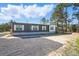 Exterior view of a modern home with gray siding, and a gravel area, showcasing its simple architecture at 1360 Burr Hill Rd, Cottageville, SC 29435