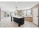 Bright kitchen with a black island, stainless steel appliances, and an open view to the living area at 1360 Burr Hill Rd, Cottageville, SC 29435