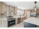 Modern kitchen with stainless steel appliances, farmhouse sink, and an island with a marble countertop at 1360 Burr Hill Rd, Cottageville, SC 29435