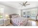 Well-lit bedroom with a ceiling fan, French doors, and a plush floral patterned bedspread at 1367 N Edgewater Dr, Charleston, SC 29407