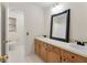 Bright bathroom featuring double sinks with modern black fixtures, wooden cabinets, and a large framed mirror at 1404 Ivy Isle Dr, Charleston, SC 29412