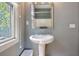 Bathroom with pedestal sink, chrome fixtures, and natural light streaming through the window at 15 Corinne St # B, Charleston, SC 29403