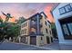 Beautiful three-story home features an elegant design, double balconies, and a two-car garage set against a sunset sky at 15 Corinne St # B, Charleston, SC 29403