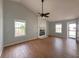 Bright living room featuring hardwood floors, a ceiling fan, and a cozy stone fireplace at 154 Tabby Creek Cir, Summerville, SC 29486