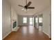 Bright living room featuring hardwood floors, a ceiling fan, and a cozy stone fireplace at 154 Tabby Creek Cir, Summerville, SC 29486