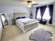 Elegant bedroom featuring a king bed, ceiling fan, carpet, and windows with blue curtains at 1540 Dawn Mist Way, Charleston, SC 29414