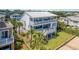 Aerial view of a beautiful home with multiple balconies, lush lawn, and convenient beach access at 1702 Palmetto Blvd, Edisto Island, SC 29438