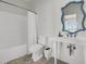 A clean bathroom features a shower-tub, toilet, sink and a blue accent mirror at 1702 Palmetto Blvd, Edisto Island, SC 29438