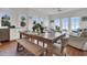 Light-filled dining area boasts a rustic wooden table and views of the beach at 1702 Palmetto Blvd, Edisto Island, SC 29438