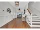 Inviting foyer featuring hardwood floors, staircase, coastal décor, and open view to the living area with water views at 1702 Palmetto Blvd, Edisto Island, SC 29438