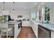 Bright kitchen featuring stainless appliances, stone counters, custom cabinetry, and hardwood floors at 1702 Palmetto Blvd, Edisto Island, SC 29438
