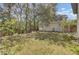 A spacious backyard featuring a lawn, bordered by trees, and a view of the home's exterior at 1844 Hubbell Dr, Mount Pleasant, SC 29466