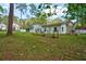 Spacious backyard featuring a white home exterior, healthy green lawn, and raised garden beds at 202 Woodland Dr, Summerville, SC 29485