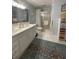 Well-lit bathroom featuring a double sink vanity, colorful accent rug, and a combined tub and shower unit at 202 Woodland Dr, Summerville, SC 29485