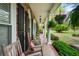 Relaxing covered porch with rocking chairs and hanging plants, providing a serene view of the yard at 202 Woodland Dr, Summerville, SC 29485