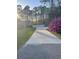 Long driveway leading to the home, flanked by lush greenery and a vibrant azalea bush at 202 Woodland Dr, Summerville, SC 29485