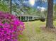 Beautiful single story home with a bright blue front door and lush landscaping, including vibrant azaleas at 202 Woodland Dr, Summerville, SC 29485