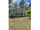 Inviting single-story home with a manicured lawn, mature trees, and a charming blue front door at 202 Woodland Dr, Summerville, SC 29485
