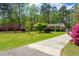 View of a home with mature trees and landscaping, including colorful azaleas, plus a paved driveway at 202 Woodland Dr, Summerville, SC 29485