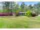 Well-maintained lawn and landscaping accentuate this house with a bright blue front door and welcoming facade at 202 Woodland Dr, Summerville, SC 29485