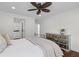 Bedroom features a mirrored dresser, ceiling fan, and hardwood floors leading to the ensuite bath at 205 Fairchild St, Daniel Island, SC 29492