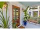 Inviting front porch with wood door, potted plants and overhead lighting at 205 Fairchild St, Daniel Island, SC 29492