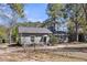 Exterior home view showing a dark roof and chimney surrounded by mature trees on a sunny day at 212 Lake Moultrie Dr, Bonneau, SC 29431