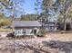Charming home with a dark roof and chimney is surrounded by beautiful mature trees at 212 Lake Moultrie Dr, Bonneau, SC 29431