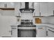 Close-up of kitchen featuring white cabinets, subway tile, and stainless steel stove at 212 Lake Moultrie Dr, Bonneau, SC 29431