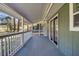 Inviting covered porch features wood floors and views of the landscaped yard at 212 Lake Moultrie Dr, Bonneau, SC 29431
