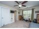 Another angle of the same bedroom, revealing doorway, exercise equipment, ceiling fan, and a bright window at 219 Tuscany Ct, Ladson, SC 29456