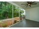 Relaxing screened patio with ceiling fan, overlooking lush backyard with mature trees providing ample shade at 219 Tuscany Ct, Ladson, SC 29456