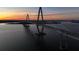 A picturesque sunset aerial view of the bridge highlighting the city skyline at 233 S Plaza Ct # 210, Mount Pleasant, SC 29464