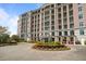 Brick apartment building showcasing manicured landscaping, roundabout, and elegant architectural details at 233 S Plaza Ct # 210, Mount Pleasant, SC 29464
