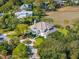 Aerial view of luxury home showcasing mature landscaping, grand facade, and circular driveway at 24 Waterway Island Dr, Isle of Palms, SC 29451