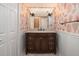 Charming powder room with coral-themed wallpaper, a dark wood vanity, and sconce lighting at 24 Waterway Island Dr, Isle of Palms, SC 29451