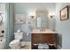 Well-lit bathroom featuring a wood vanity, framed mirror, and blue-gray walls with a painting at 24 Waterway Island Dr, Isle of Palms, SC 29451