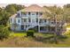Beautiful elevated home with a porch and lush landscaping offers stunning curb appeal at 24 Waterway Island Dr, Isle of Palms, SC 29451